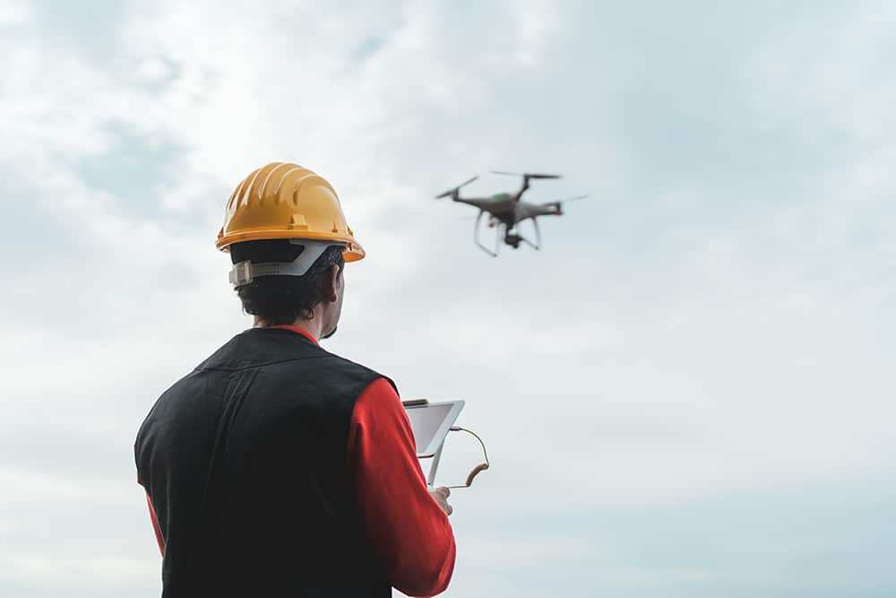 Male engineer monitoring construction site with drone - Technolo